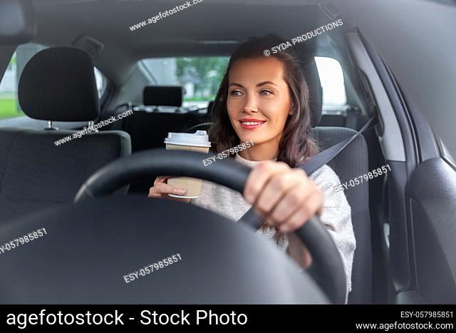 woman or female driver with coffee driving car