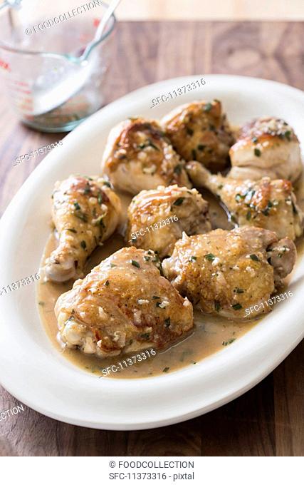 Braised chicken pieces with a vinegar sauce on an oval plate