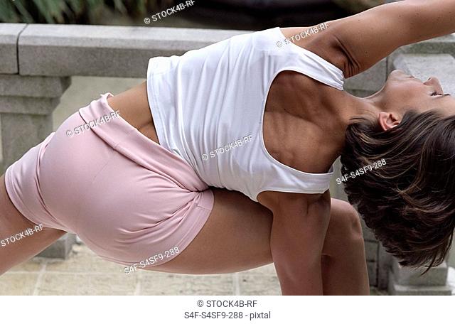 Darkhaired Woman bending over one Side - Physical Exercise - Yoga