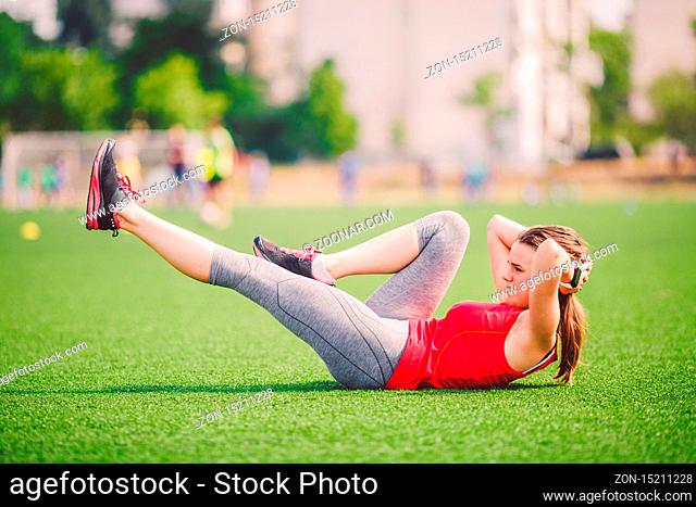 Theme sport and health. Young beautiful Caucasian woman doing warm-up, warming up muscles, abdominal muscles workout, losing belly