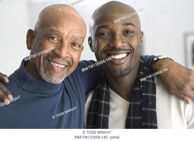 African father and adult son hugging