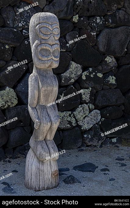 Guardian wooden tiki in front of big wall, Pu'uhonua O Honaunau National Historical Park, Big Island, Hawaii