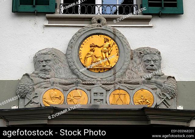 Golden emblems on the exterior wall of a building at Muehlenplatz in Lucerne, Switzerland