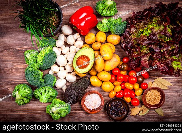 Assorted raw vegetables on wooden background