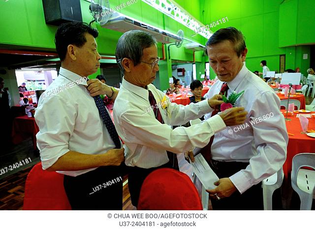 Learning to tie a necktie before the Chinese New Year dinner at Sungai Maong Community Hall, Kuching, Sarawak, Malaysia