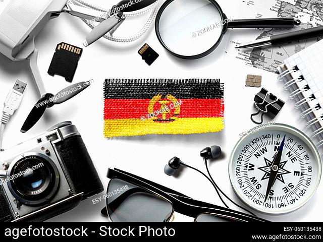 Flag of GDR and travel accessories on a white background. The view from the top