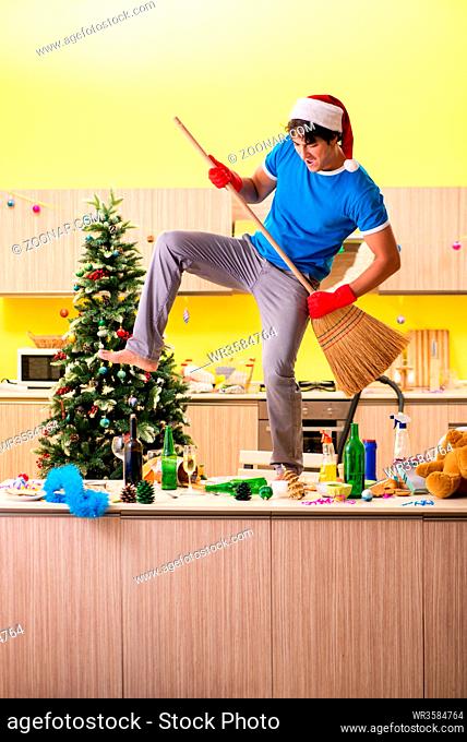Young man cleaning kitchen after Christmas party
