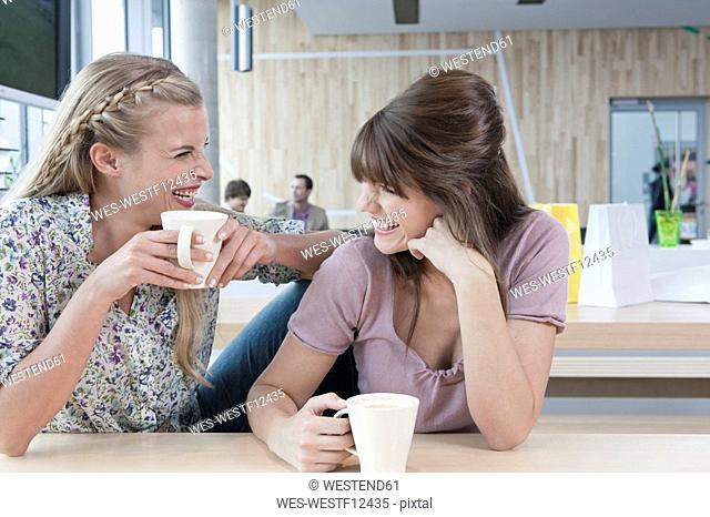 Germany, Cologne, Young women in cafe, having fun
