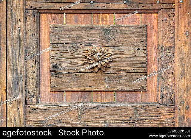 a small flower carved on an old wooden door