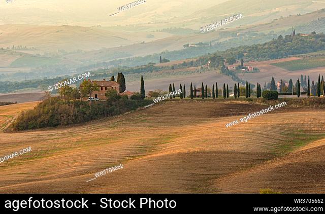 Beautiful idyllic farmland with meadow field and farmhouse at Tuscany area near Pienza touristic village, Italy, Europe
