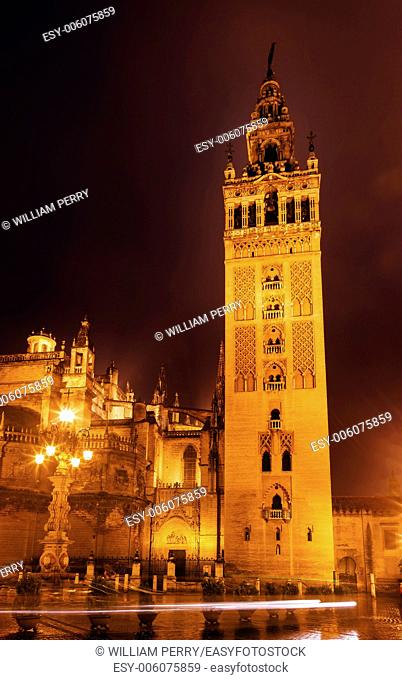 Giralda Spire, Bell Tower, Seville Cathedral, Rainy Night, Car Trails, Seville, Andalusia Spain. Built in the 1500s. Largest Gothic Cathedral in the World and...