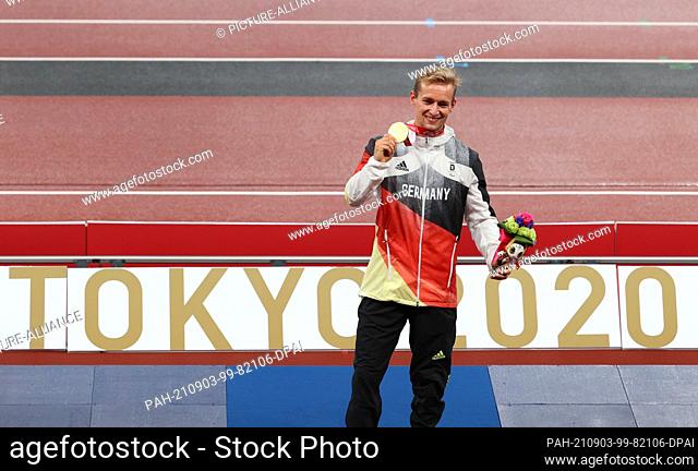 03 September 2021, Japan, Tokio: Paralympics: Athletics, men's 400 metres, T62 final, at the Olympic Stadium. Johannes Floors holds up his gold medal at the...