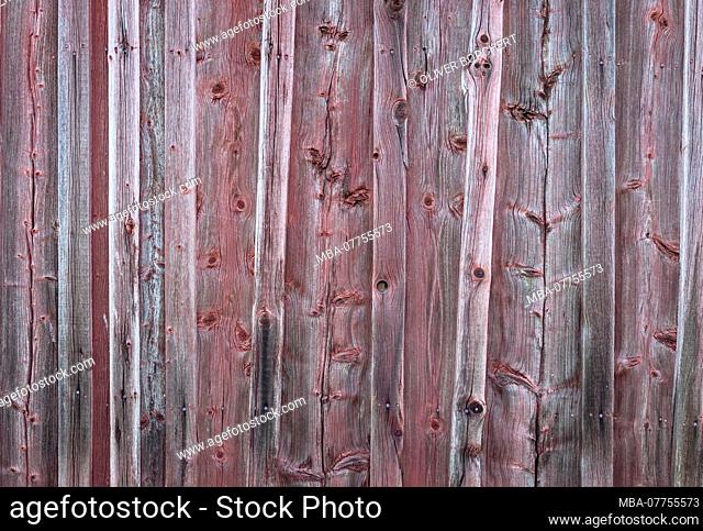 Wall of a red wooden house, old, weather-beaten, detail