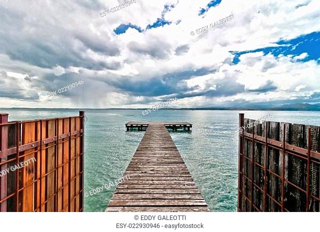 pier and dramatic sky over Garda lake - Italy