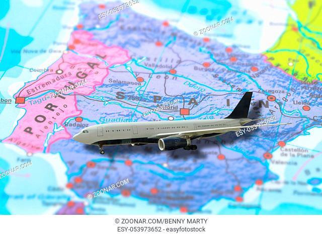 flight of airplane travelling to Madrid in Spain on colorful political map of Europe. Geopolitical school atlas. Holidays and travel concept
