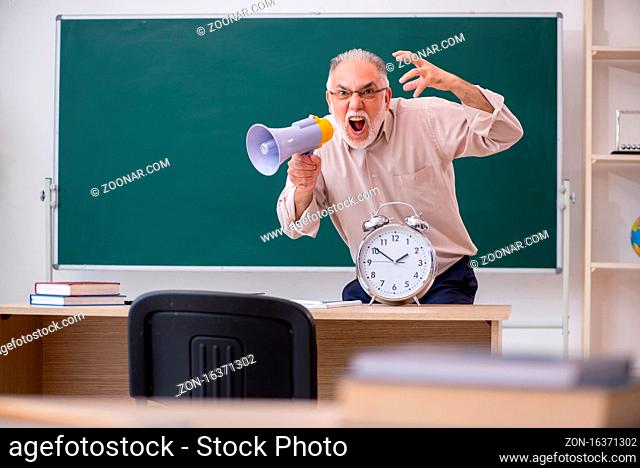 Old senior teacher in time management concept