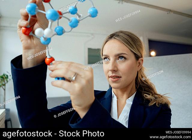 Businesswoman analyzing molecular structure model in office