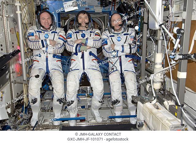 Attired in their Russian Sokol launch and entry suits, Russian cosmonaut Oleg Kononenko (center), Expedition 31 commander; along with European Space Agency...