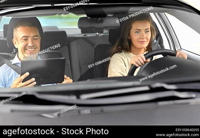 woman and driving school instructor talking in car