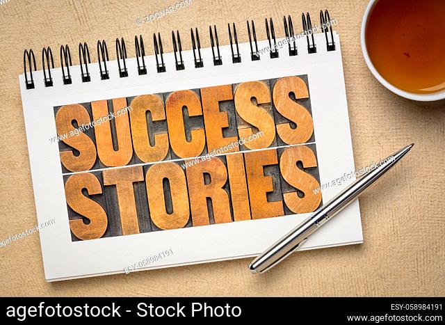 success stories typography - word abstract in vintage letterpress wood type in a spiral sketchbook with a cup of tea, career