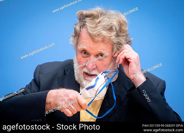 09 November 2020, Berlin: Thomas Mertens, Chairman of the Standing Commission on Vaccination (STIKO), takes off the mouth and nose cover at the beginning of the...