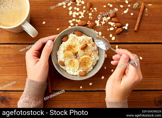 hands with oatmeal breakfast and cup of coffee