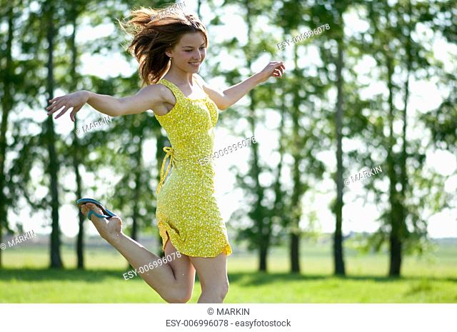 Beautiful young woman runing in apple tree garden