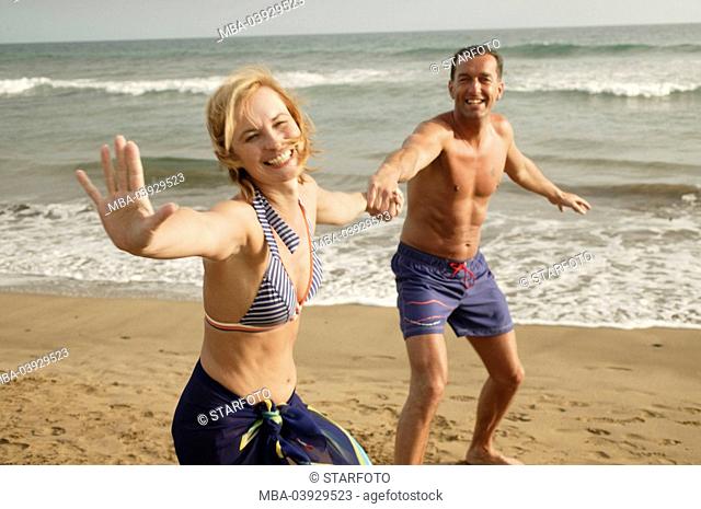 Pairs, running, broached lake, cheerfully, hand in hand, beach