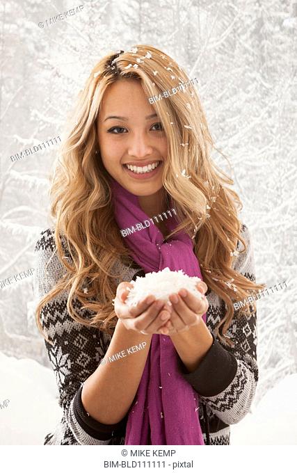 Mixed race woman holding handful of snow