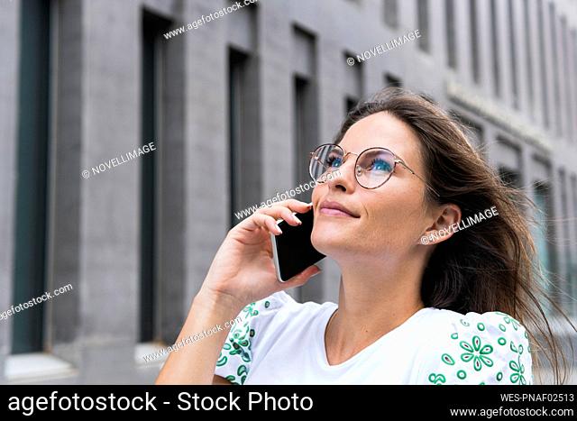 Businesswoman talking on smart phone looking up