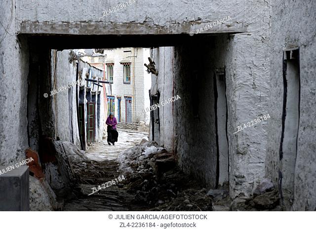 Woman in a street of the walled city of Lo Manthang, the historical capital of the Kingdom of Lo. Nepal, Gandaki, Upper Mustang (near the border with Tibet)