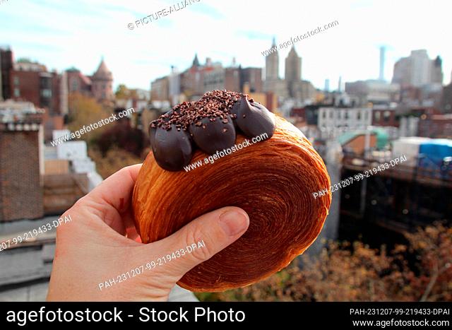 17 November 2023, USA, New York: A woman holds a ""suprême"" - a kind of croissant filled with chocolate cream. (to dpa-KORR ""Ten years ago