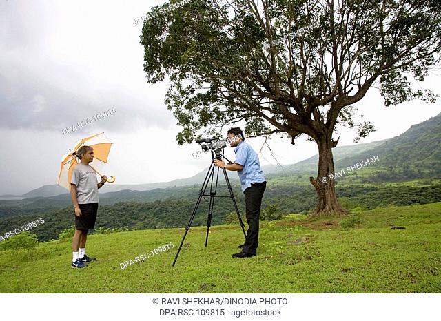 shooting  ; Man taking pictures ; Matheran ; Maharashtra ; India MR202