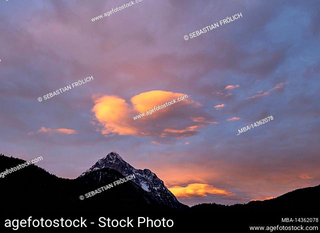 Sunrise with colorful clouds and view from Mittenwald to Wetterstein, a prominent mountain range in the German Alps
