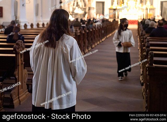 PRODUCTION - 28 September 2022, Hesse, Fulda: Altar boys walk through the cathedral during a morning service in Fulda Cathedral as part of the fall plenary...