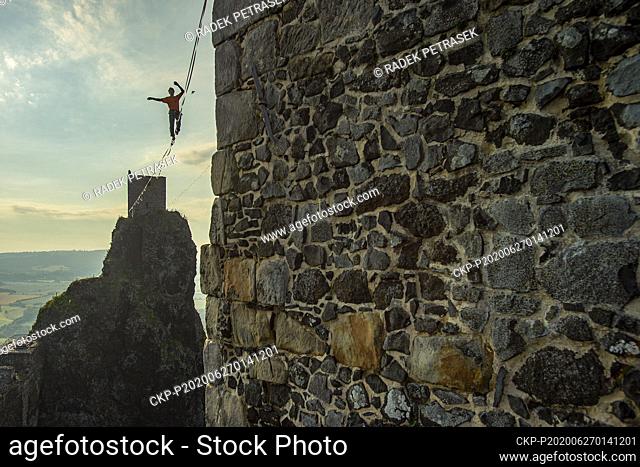 A slackliner performs slacklining at height of 50 meters between two towers of the Trosky Castle, Czech Republic, on June 27, 2020