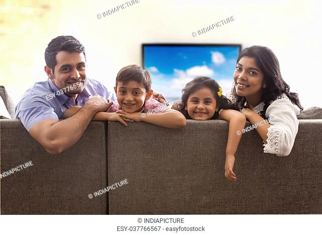 Portrait of family sitting on sofa in living room