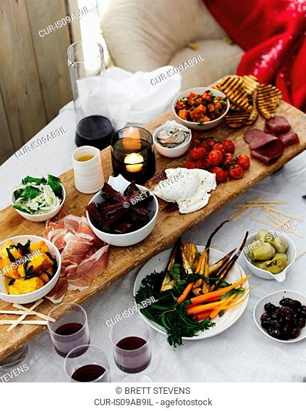Dining table selection of antipasto with red wine