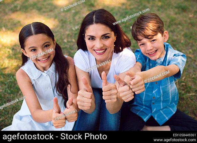 Teacher And Children Showing Thumbs Up After Having Lesson In Park. Creative Education Concept
