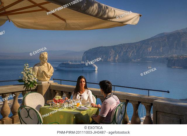 Couple sitting at a restaurant on the terrace of a hotel, Sorrento, Campania, Italy