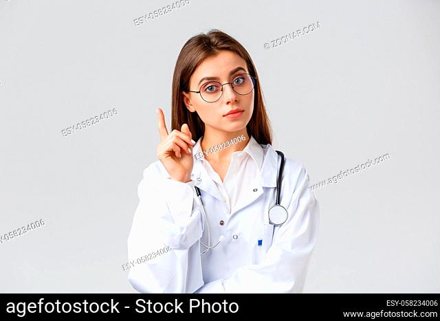 Healthcare workers, medicine, insurance and covid-19 pandemic concept. Smart professional female doctor in white scrubs and glasses, have idea, suggestion