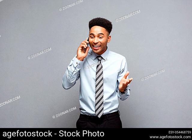 Business Concept - Cheerful professional african american businessman happy talking on mobile phone with client