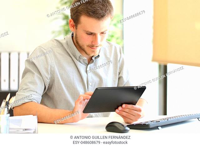 Entrepreneur working on line with a tablet sitting in a desk at office
