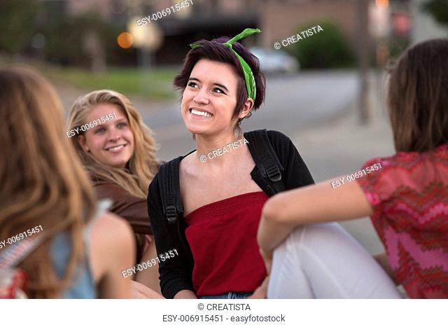 Happy Hispanic teenage girl with friends looking away