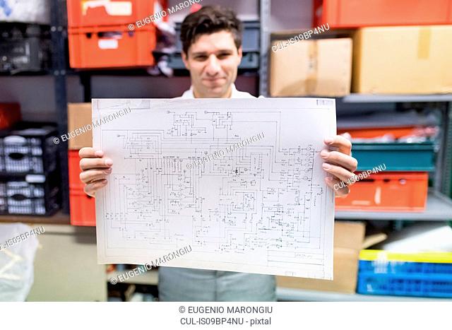 Man working on charts and plans in warehouse