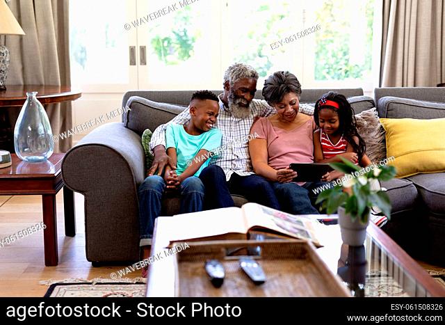 Senior mixed race couple with their grandchildren at home