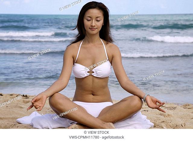 Chinese Young Woman Doing Yoga On The Beach, America