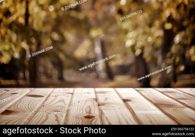 Empty wooden table with autumn Park view in the background for product display mounting