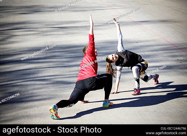 Man and woman exercising on asphalt road