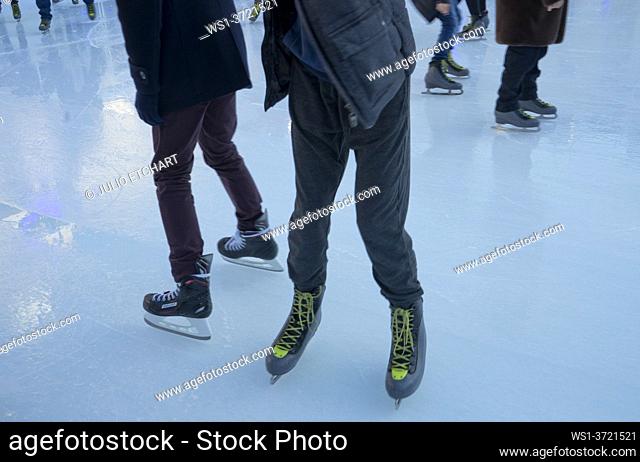 Young people ice-skating in the winter in an ice rink in Glasgow, Scotland, UK